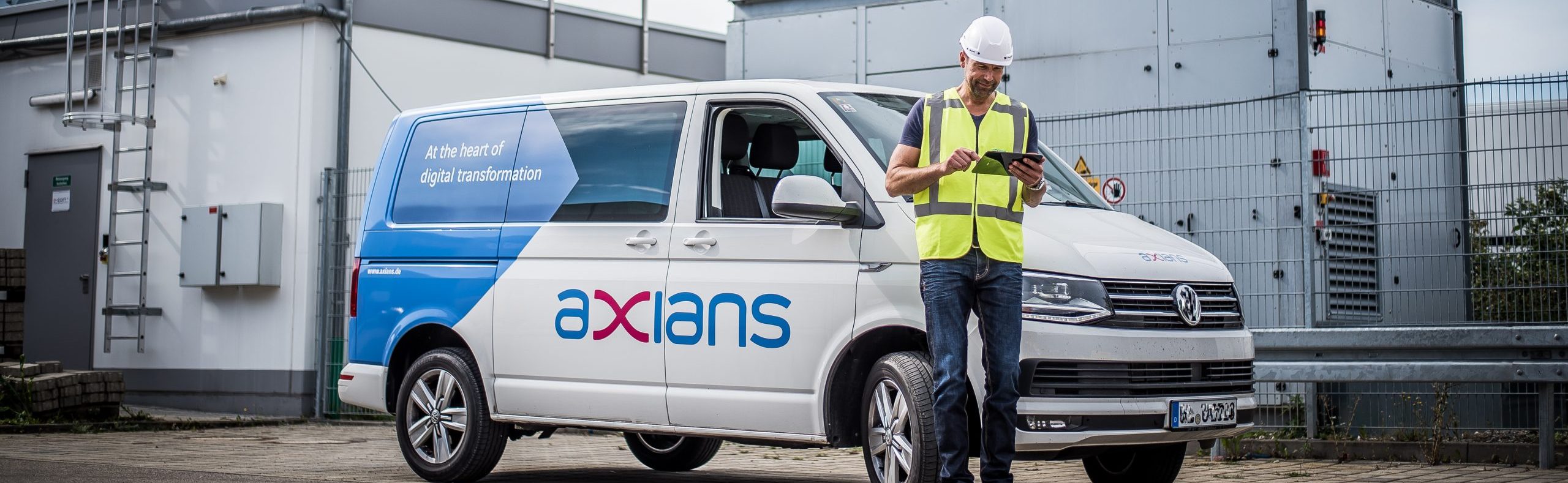 Axians arbetare på site med servicebil